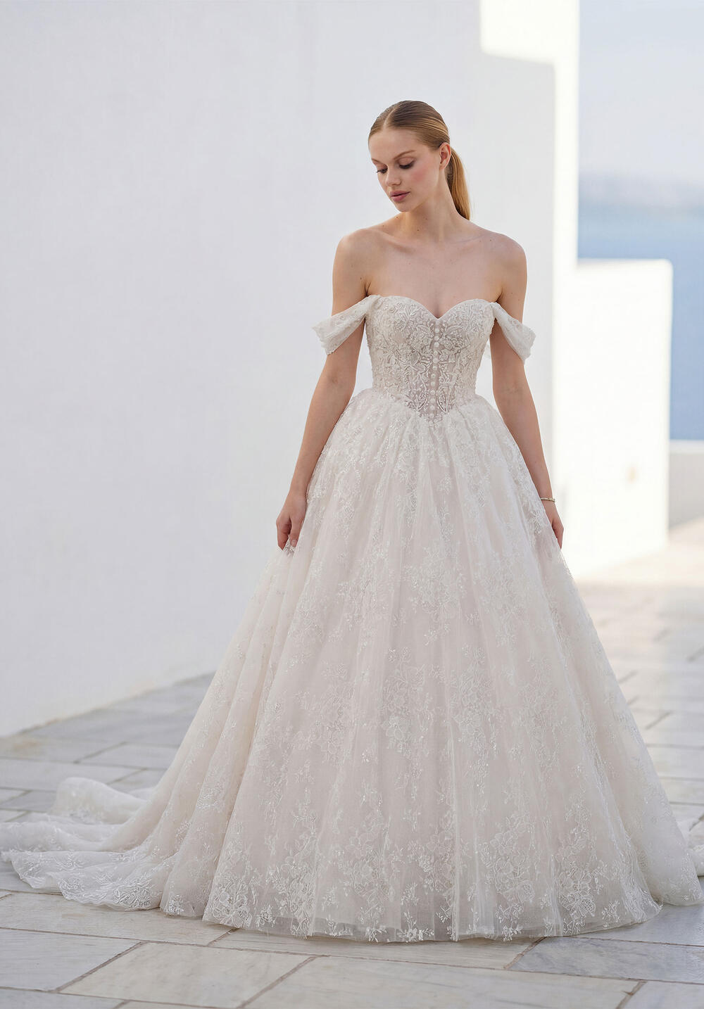 Morilee off-the-shoulder lace ball gown on a whitewashed terrace