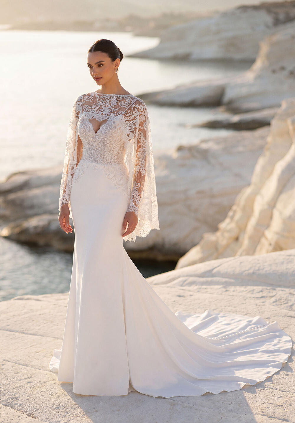 Morilee crepe fit and flare gown with a lace capelet on white cliffs